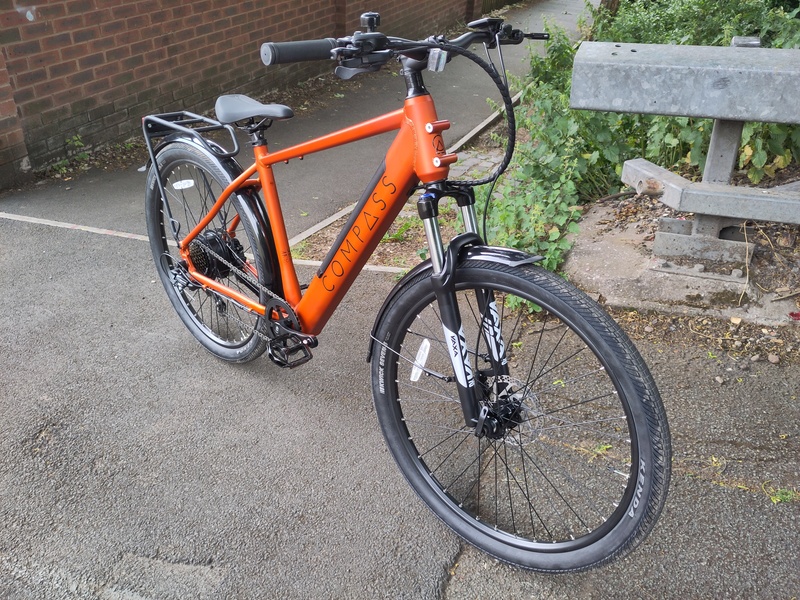 An orange Compass ebike, seen from front right