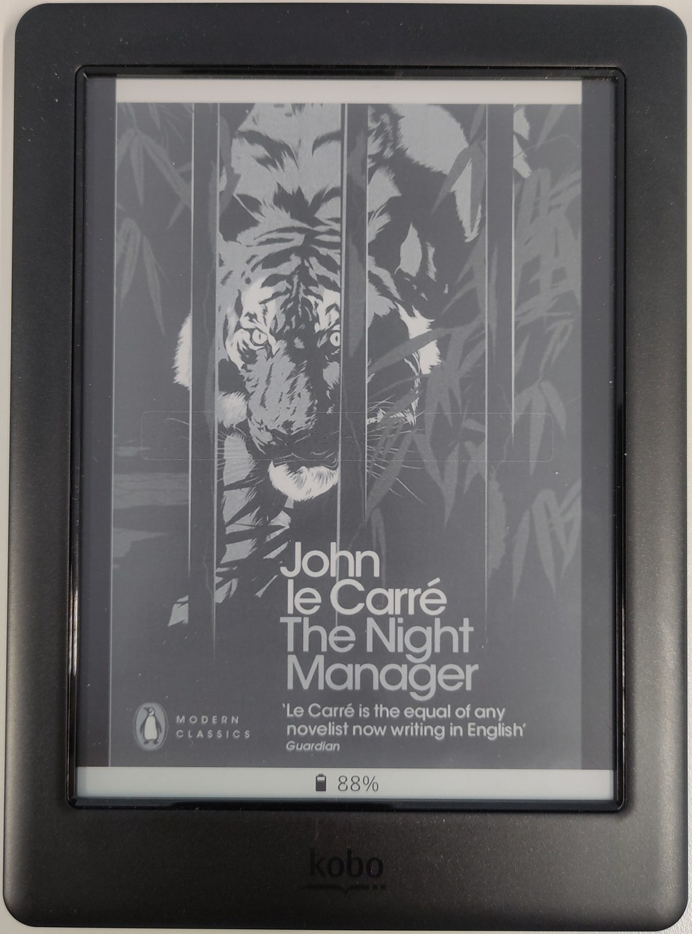 Kobo ereader. On the screen is the cover of the book "The Night Manager" by John le Carré. In the centre at the bottom is an icon of a battery and the text "88%"